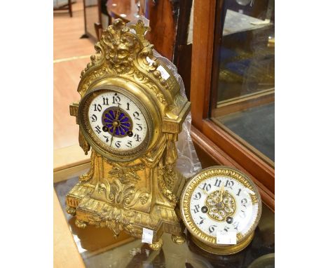 A French gilt metal mantel clock, ornate enamel dial with Arabic numbers, the waisted body cast with emblems, swags, on bun f
