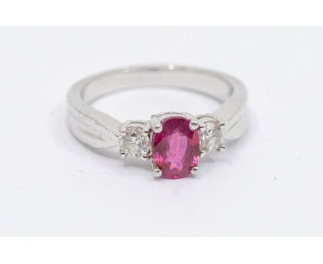 A ruby and diamond platinum Iliana ring, comprising an oval claw set ruby approx 5 x 7mm, with single diamonds set either, to