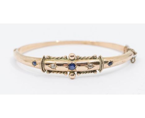 A Victorian sapphire and 9ct gold bangle, comprising a star set round cut sapphire to the centre with star set old cut diamon
