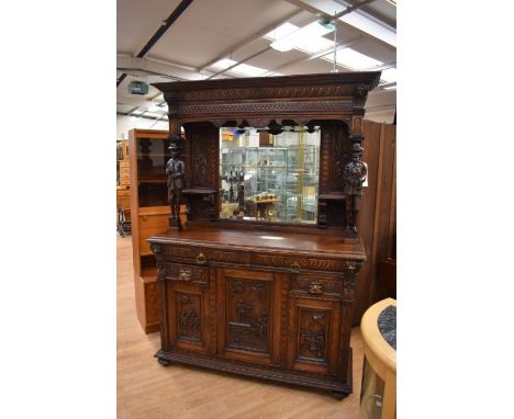 A large solid oak Victorian mirror-back Sideboard with two carved supports of men playing bagpipes at the top and carved base