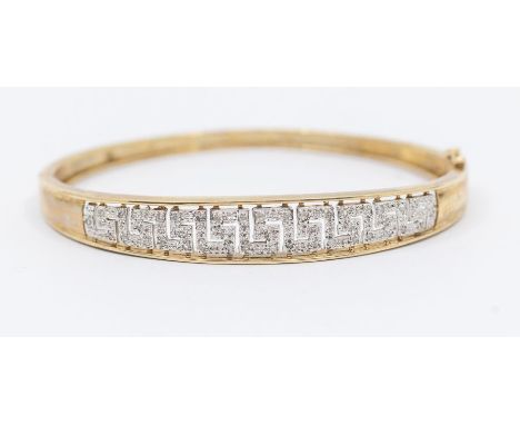 A diamond set 9ct gold bangle, comprising a white gold graduated Greek Key pierced detail,  grain set with small diamonds, di