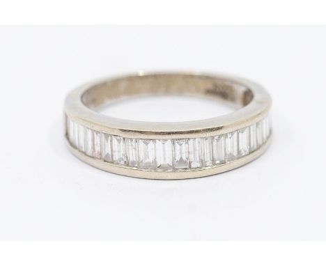 A diamond and 18ct white gold half eternity ring, comprising a graduated row of baguette cut diamonds, channel set, width app