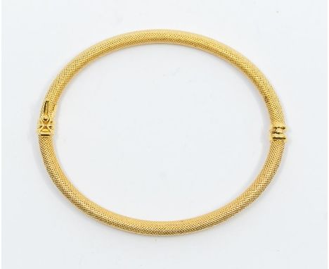 An 18ct gold textured bangle, comprising a round section hollow bangle with cross hatch textured finish, internal diameter ap