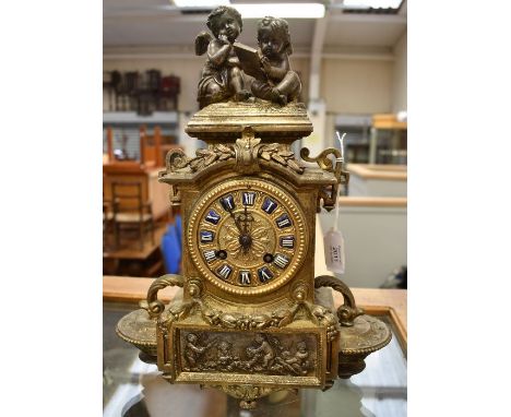 A French mantle clock contained in a spelter case cast decorations of leaves and grapes, plaque on the front of cherubs playi