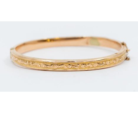 A 9ct gold bangle with ornate engraved pattern, hinged, weight approx 7.3gmsFurther details: dents to reverse, repair to inte