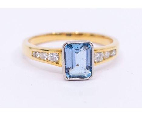 An aquamarine and diamond 18ct gold ring, comprising a rub over set emerald cut aquamarine approx 5 x7mm, the shoulders with 