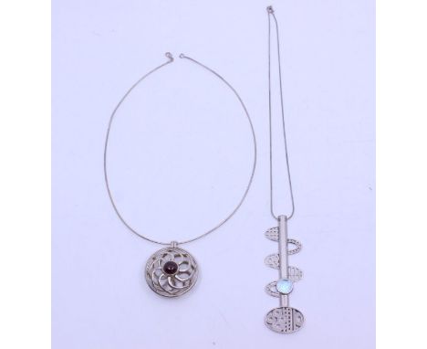 Two silver stone set pendants to include a circular wire work pendant set to the centre with a round cabochon garnet, size ap