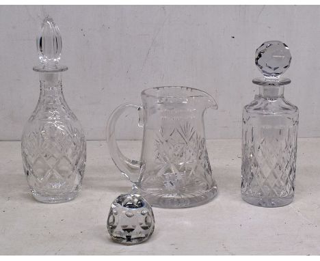 A small collection of vintage clear moulded glass including 2 decanters with original stoppers, a large jug and a paperweight