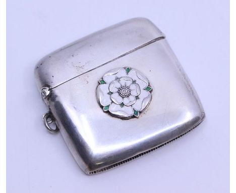 A George V silver and enamel vesta case, plain body the centre applied with stylised White Rose of Yorkshire, on suspension r