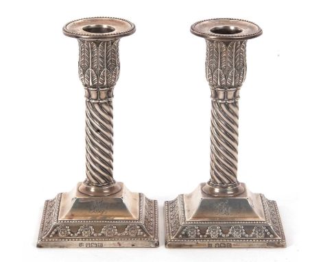 A pair of Edward VII silver candlestick with acanthus leaf caps, fluted swirl design columns to a stepped square loaded base 