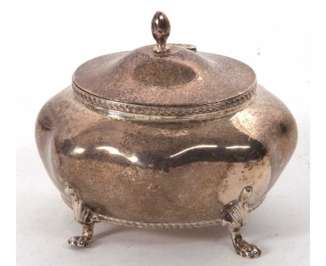 An Edwardian silver caddy of plain bombe design with hinged lid and urn finial with applied gadrooned rims, supported on four