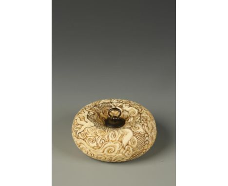 A LARGE JAPANESE MANJU NETSUKE by Hasegawa Ikko, the entire surface carved with a dragon amongst clouds, the two parts held t