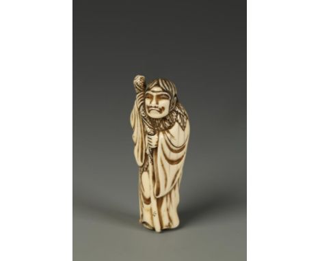 A JAPANESE IVORY SENNIN NETSUKE, the figure standing with a wizened expression and holding a long staff, unsigned, circa 1800