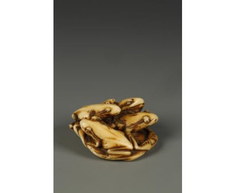 A JAPANESE IVORY FROG GROUP NETSUKE, the five creatures perching on a lotus leaf, signed Seimin, circa 1880, 1.5" long