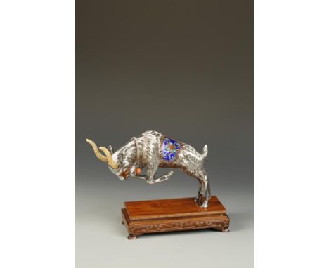 A CHINESE SILVER AND ENAMEL GOAT, the animal charging forward, wearing an ornate saddle with enamel decoration, 20th century,