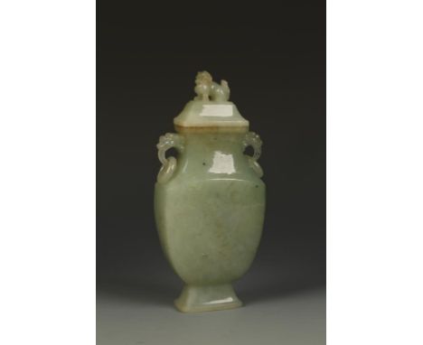 A CHINESE CELADON JADE COVERED VASE of rounded rectangular form, with a lion finial and mask and ring handles above the taper