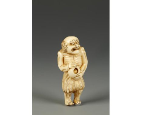 A JAPANESE IVORY NETSUKE OF A FISHERMAN, the emaciated figure with an alarmed expression and holding a Tama, circa 1820, 2.25