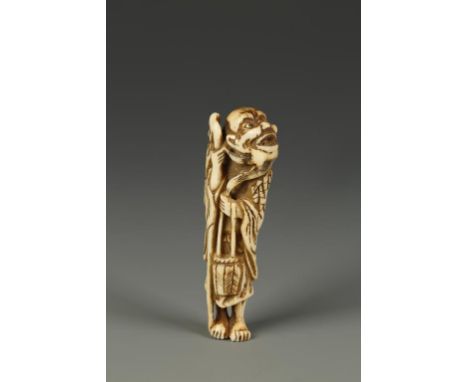 A JAPANESE STAG ANTLER TEKKAI SENNIN NETSUKE, the figure looking upwards and holding a staff, circa 1820, 3" high