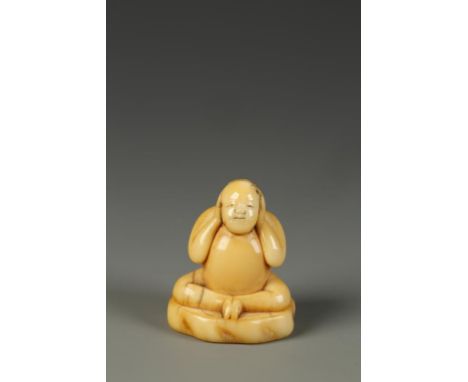 A JAPANESE IVORY FIGURAL TOBORI NETSUKE, the plump Chinese style boy clasping his hands over his ears in order to hear no evi