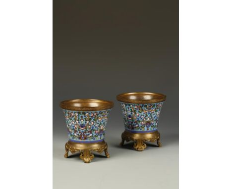 A PAIR OF CHAMPLEVE ENAMEL CACHEPOT decorated in polychrome with flowerheads and tendrils, on a turquoise ground, with Europe