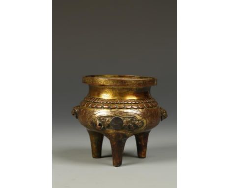 A CHINESE GILT-COPPER TRIPOD CENSER, the waisted neck with a circular floral-decorated band, above the double-lappet shoulder