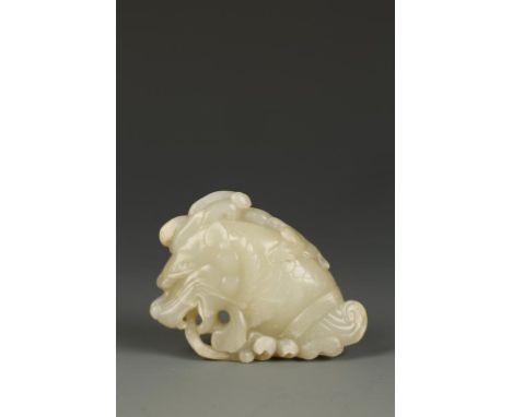 A CHINESE CELADON JADE DRAGON-FISH CARVING, the creature with a chilong dragon crawling on its' head with waves below, Qing, 