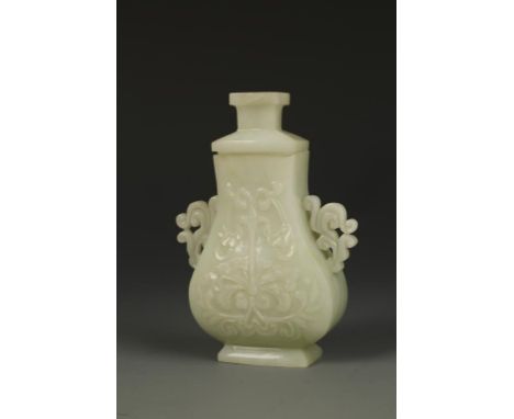 A CHINESE PALE CELADON JADE COVERED VASE of baluster form, carved in low-relief with flowers and foliage, with scroll handles