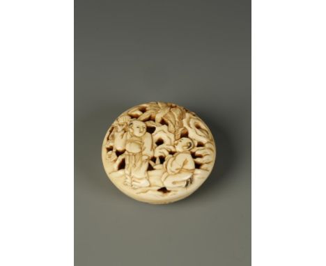 A JAPANESE IVORY MANJU NETSUKE carved in openwork showing scholars in a landscape, circa 1900, 1.5" dia. 