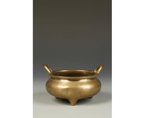 A CHINESE BRONZE TRIPOD CENSER with loop handles above the squat rounded body, the base with a stylised Xuande mark, Qing,17t