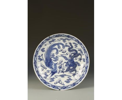 A CHINESE BLUE AND WHITE 'DRAGON AND PHOENIX' CHARGER, the centre with a dragon and phoenix either side of a flaming pearl am