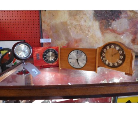 A collection of four vintage clocks including a Pesta Nova spherical clock, a red faux mother of pearl clock and others
