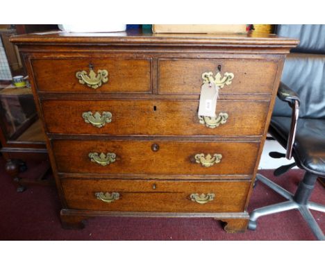 A Georgian oak chest of two short over three long graduated drawers with brass handles, raised on shaped bracket supports 