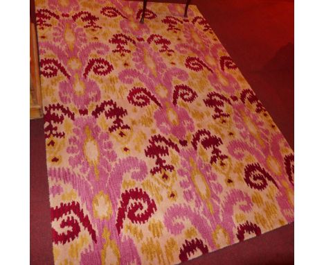 A contemporary wool carpet with pink, red and yellow designs on a grey field 231 x 161cm 