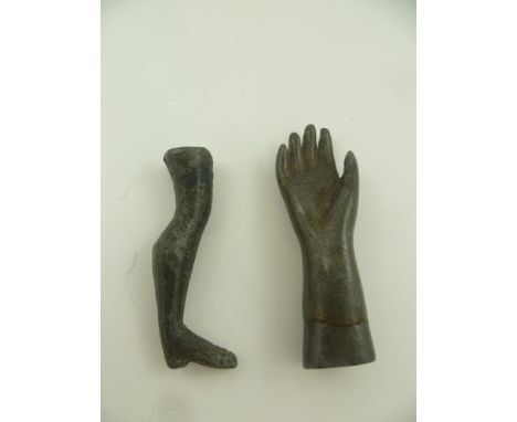 TWO 19TH CENTURY CAST METAL PIPE TAMPERS one in the form of a leg 6cm long, the other in the form of a hand, 6.5cm long 