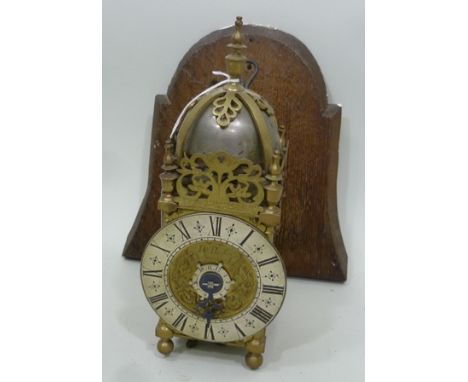 A LATE 19TH/EARLY 20TH CENTURY GEORGIAN STYLE BRASS LANTERN CLOCK, having turned finial and bell top, silvered chapter, signe