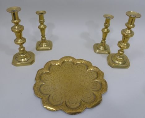 A PAIR OF BRASS CANDLESTICKS with drip pans over graduated bobbin stems and dished bases, 55cm high together with two smaller