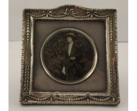 BOOTS PURE DRUG COMPANY A SQUARE SILVER PHOTOGRAPH FRAME, having pressed decorated garland surround and matching hallmarked c