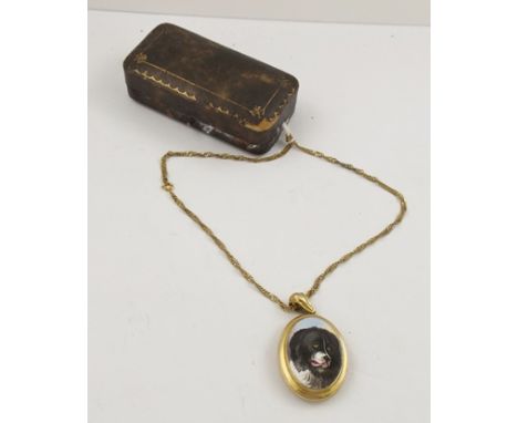 A GILDED YELLOW METAL LOCKET with a profile of a dog in enamel, on a modern chain, in a Harrod's vending box, 40cm long 
