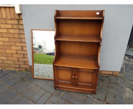 Ercol - A Waterfall bookcase with lower twin door cupboard section, approximately 110 cm x 61 cm x 35 cm and a mirror. [2]