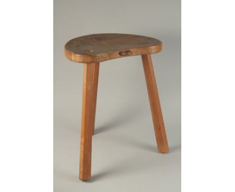 A GOOD MOUSEMAN OAK STOOL with kidney shaped top, on three legs. 18ins high.