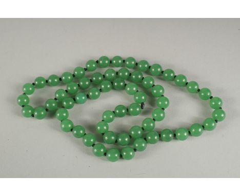 A STRING OF JADE BEADS.  24ins long.