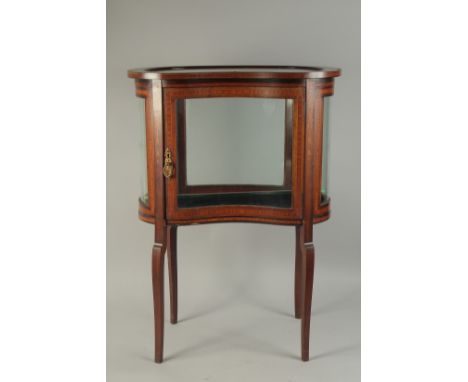 A GOOD MAHOGANY KIDNEY SHAPED BIJOUTERIE CABINET with glass sides and glass door, opening to reveal a glass shelf and support