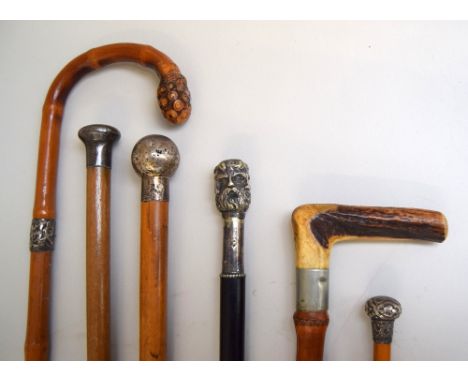 A late 19th century ebony walking cane with Janus style six faced white metal knop, three other canes with white metal knops,