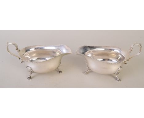 A matching pair of Edwardian silver Mappin & Webb gravy boats with wavy rims and paw feet, Sheffield 1930, 430g