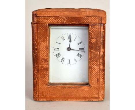 An Edwardian brass carriage timepiece with white enamel face in a leather case