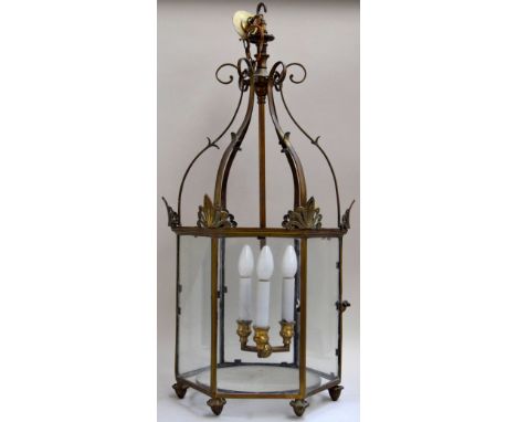 A Regency style gilt and patinated brass hall lantern of hexagonal section, with a three light hanging fixture, with scrollin