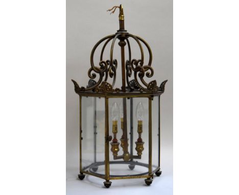 A gilt metal and glazed hall lantern in the Regency style, 20th century, of hexagonal section, the hanging loop above downtur