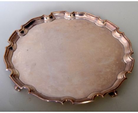 A George II  style silver salver of circular pie crust form with scrolled feet, Sheffield 1938, makers Roberts and Belk, 827g
