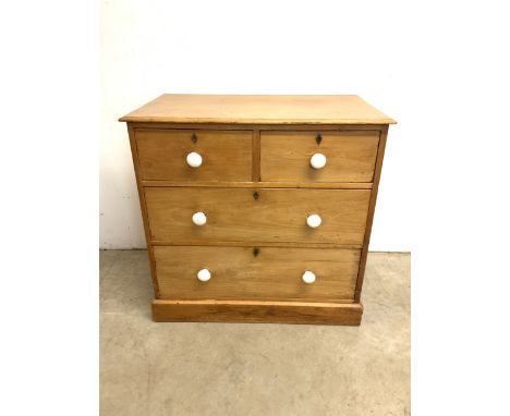 A Victorian pine chest of drawers stamped Heal and sons London. With ceramic handles on two short over two long drawers. W:92