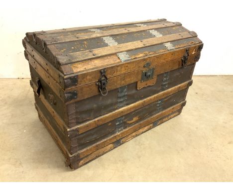 A wooden and metal bound domed top steamer trunk. W:84cm x D:51cm x H:58cm
